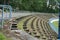 A football stadium tribune in disrepair or decayed in a provincial town in Eastern Europe. Wooden seats were removed since decayed