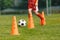 Football Training Background. Orange Practice Cone. Player Running Ball in Slalom Drill in Blurred Background