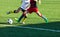 Football training soccer for kids. Boy runs kicks dribbles soccer balls. Young footballers dribble and kick football ball in game.