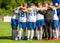 Football Youth Team Huddling with Coach. Young Happy Boys Soccer Players Gathering