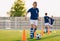 Footballer running with ball on training pitch. Soccer practice for junior level team