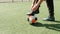 Footballer soccer player in boots tying shoelaces on field