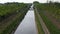 footbridge across the river between fields and tree planting in the park