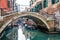 Footbridge and boats in water canal, Venice - Italy