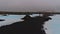 Footbridge crossing pools of blue water in lava field near geothermal spa resort Blue Lagoon, Grindavik, Reyjanes, Iceland.