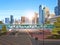 Footbridge over highway asphalt road with marking arrows traffic signs city skyline modern skyscrapers cityscape