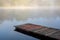 Footbridge over a misty pond in Bukowiec during sunrise.