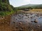 Footbridge over the River Lyd with crystal clear water and rocks, Dartmoor