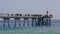 Footbridge over the sea with people walking a festive morning