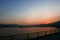 Footpath, fence, sea and mountain at sunset