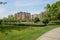 Footpath in grassy lawn before modern buildings on sunny summer