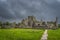 Footpath leading to old ruins of Hore Abbey with dark dramatic storm sky