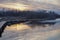 Footpath over a lake at sunset surrounded by woods