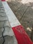 The Footpath road. Red and white concrete sidewalk curb with brick