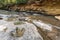 Footprint of dinosaur Carnotaurus on ground near stream at Phu Faek national forest park , Kalasin ,Thailand . Water logged on