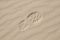 Footprint on light sand with diagonal pattern