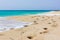 Footprints along seashore on empty beach with turquoise water