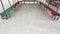 Footprints on clean white snow surface inside outdoor pavilion with colorful painted benches of kids playground with nobody.