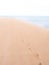 Footprints on an empty tropical beach fading towards horizon