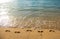 Footprints at golden sand, footsteps. Tropical beach with sea sand on summer vacation.