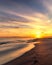 Footprints leading off into the sunset along a beautiful beach.