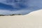 Footprints on the sand of the Little Sahara desert on Kangaroo Island, Southern Australia, with blue skies in the background