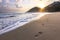 Footprints on sand of running girl on sandy seashore at sunrise in thailand