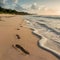 Footprints on sandy beach being washed away, transient imprints