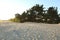 Footprints shoes and wind on the sand beach in the summer evening in the rays of the setting sun natural background