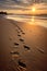 footprints trailing off into the distance on a sandy beach