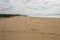 Footprints and Vehicle Tracks Leading Across Expansive Beach