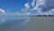 Footprints are visible on the wide sandy beach.