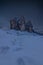 Footsteps in the snow in front of Tre Cime di Lavaredo, UNESCO heritage site in the Italian Dolomites, on a starry night