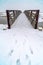 Footsteps in the snow leading to a bridge in Utah