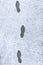 Footsteps on a snowy asphalt