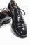 Footwear Concept. Closeup of Pair of Formal Male Stylish Black Polished Oxford Leather Laced Shoes Placed Together Over White