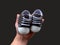 Footwear for the smallest children. Slippers for babies in hand. Children`s shoes of small size, isolated on black