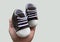 Footwear for the smallest children. Slippers for babies in hand. Children`s shoes of small size,  on white