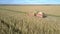 Forage combine drives past vehicle unloading cut crop