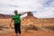 Forced perspective of a senior adult woman 60s pretending to touch a rock formation