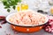 Forcemeat. Raw ground chicken meat in bowl on white kitchen table. Fresh minced chicken breast meat