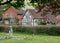 In foreground, graves in grounds of St Mary the Virgin Church in Turville in The Chilterns, with characterful houses behind.