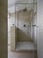 Foreground the masonry shower box with glass door in the modern bathrrom the walls are coated of marble