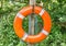 Foreground of an orange lifesaver hanging on a wooden column