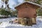 Foreground of water well and pump house in OÂ´Donnel park in Alcala de Henares on a sunny day after a snowfall