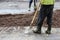 foreman of builders and a worker with a shovel stand near the problem area of the road before work on extracting soil, its prepara