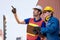 Foreman and cargo container worker discuss and point to the direction of transport the product in workplace area. Business