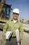 Foreman With Clipboard And Blueprint At Site