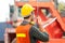 Foreman in hardhat and safety vest holding holding clipboard checklist and talks on two-way radio control loading containers box