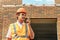 Foreman inspector or construction worker in hardhat portrait. Engineer in helmet with walkie-talkie in hand directs